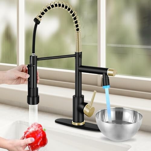 Modern black and gold kitchen faucet with dual spray modes.